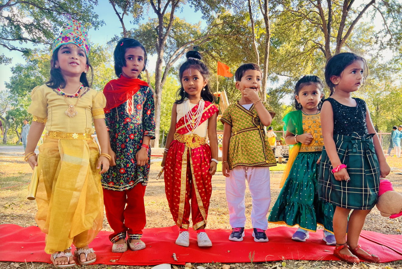 Young Aum School children in traditional festival attire standing together outdoors